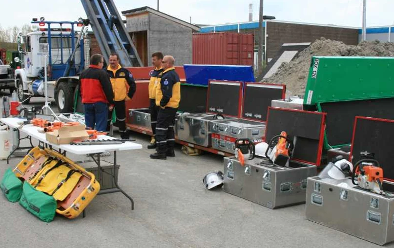 Rescue team briefing beside a full lineup of staged P.E.T.S. cases