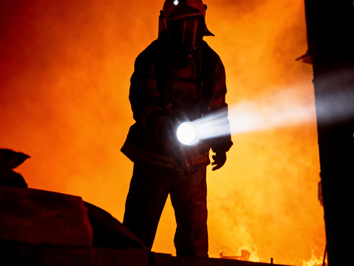Search and rescue responder with flashlight in smoke