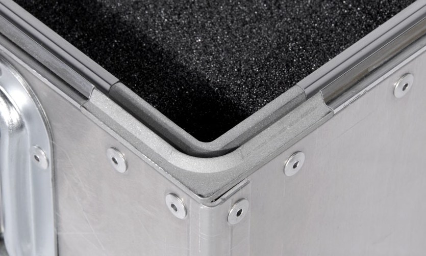Close-up of the patented Impact Cases valance system — investment cast corner lug and dual gasket seal at the case rim